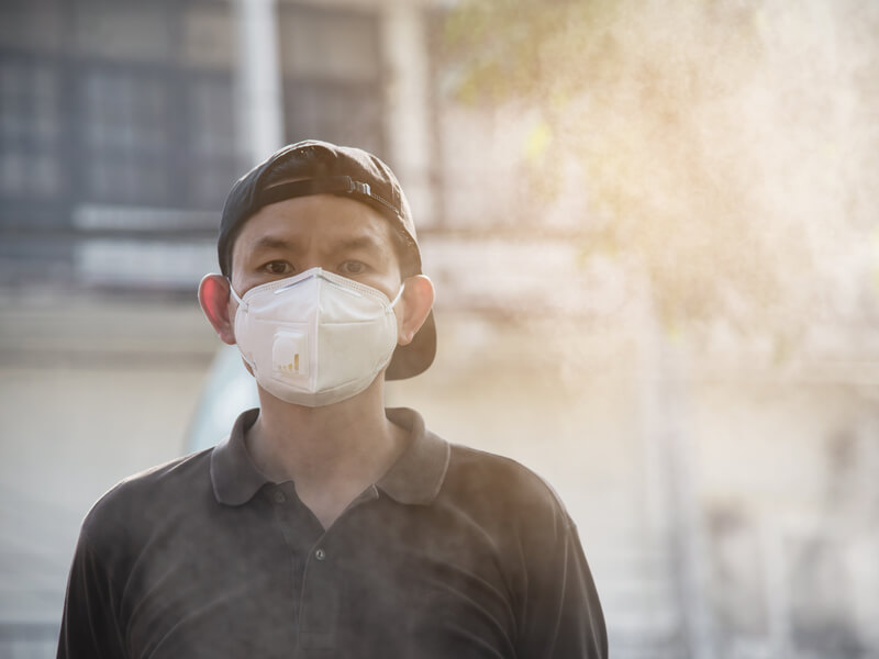 ผู้ชายสวมหน้ากากป้องกันมลพิษทางอากาศ